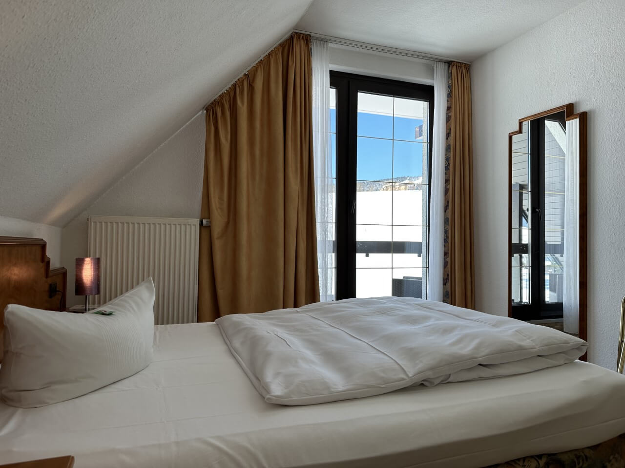 Einzelzimmer Blick auf Doppelbett, Fenster und Spiegel