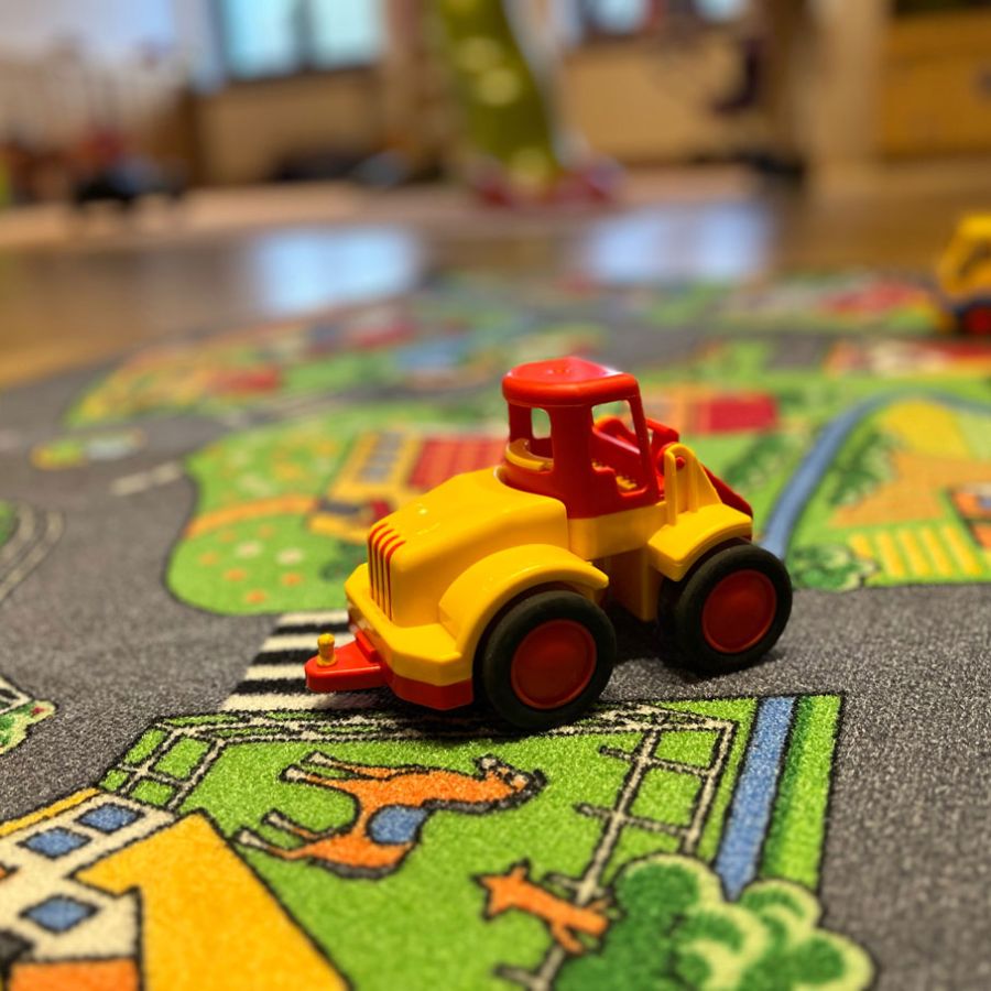 Spielzeugbagger auf Autoteppich, Nahaufnahme