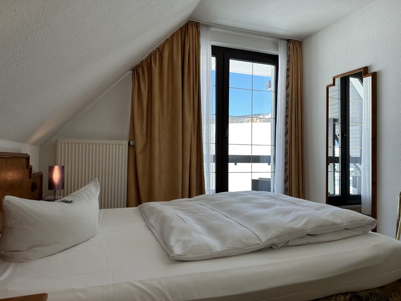 Einzelzimmer Blick auf Doppelbett, Fenster und Spiegel