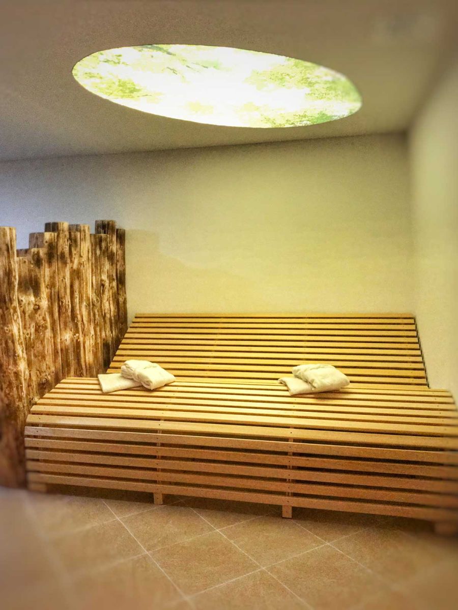 Entspannungsbereich aus Holz neben Sauna